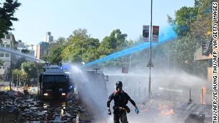 Police launch water cannon and tear gas outside the Hong Kong Polytechnic University to disperse protesters in Hong Kong on Sunday.