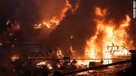 Fires burn at the steps to Hong Kong Polytechnic University as police storm the campus early Monday, November 18, 2019. 