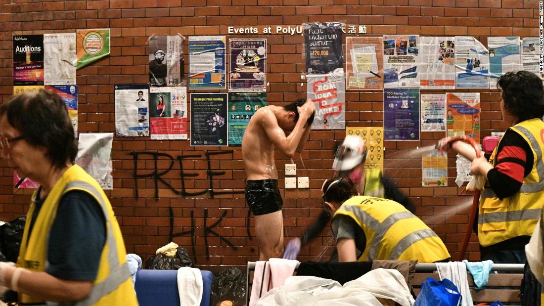 An anti-government protester is showered down by volunteer medical workers after he was soaked by a police water cannons firing pepper spray-infused water at Hong Kong Polytechnic University on November 18.