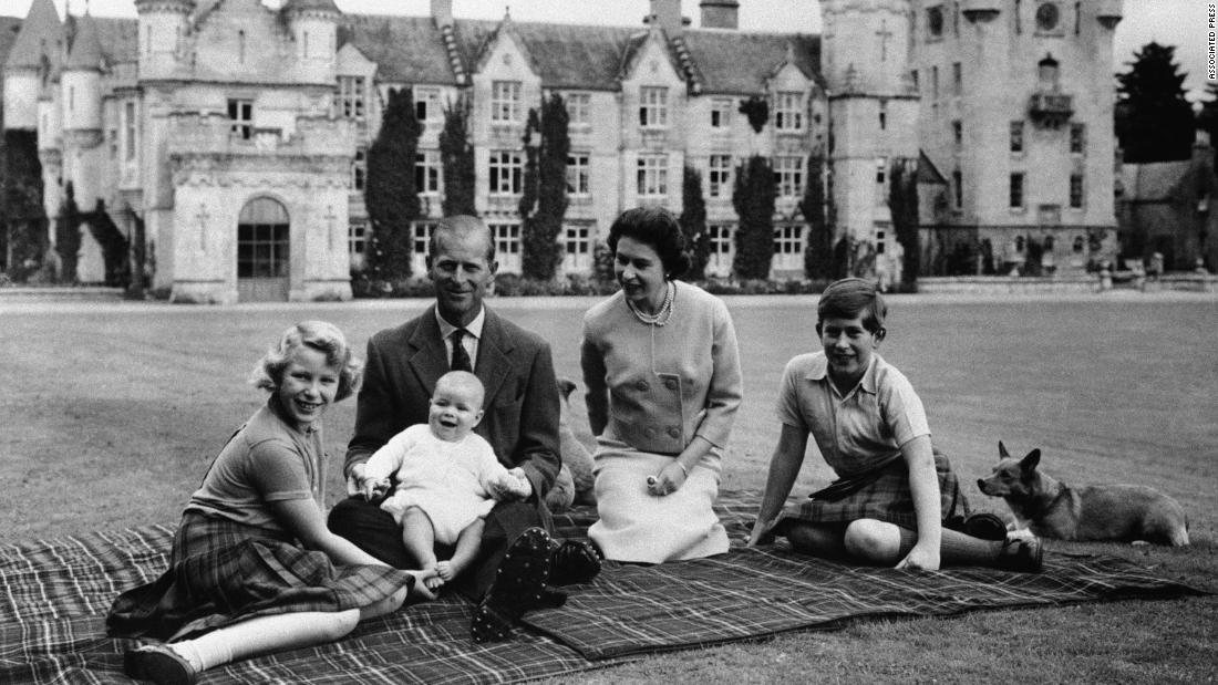Prince Andrew sits on his father&#39;s lap during a holiday in Scotland in September 1960. At left is his sister, Princess Anne. At right, next to the Queen, is his brother Prince Charles.