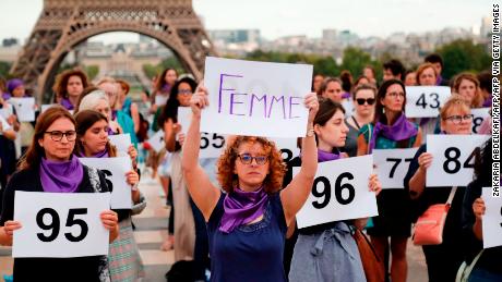 A person holds a placard reading &quot;Woman&quot; as people gather on the Trocadero square in front of the Eiffel tower in Paris during a demonstration called by the &quot;Nous Toutes&quot; feminist organisation to denounce the 100th feminicide of the year, on September 1, 2019. - For the year 2018, the Ministry of the Interior had identified 121 feminicides. (Photo by Zakaria ABDELKAFI / AFP)        (Photo credit should read ZAKARIA ABDELKAFI/AFP via Getty Images)