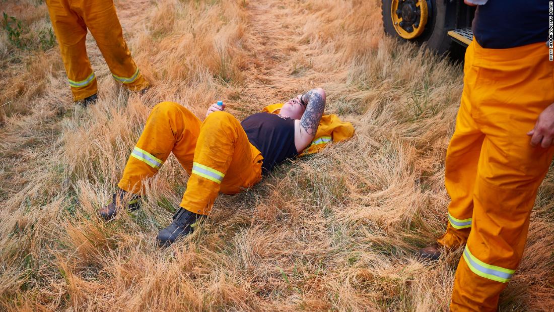 A CFA crew member rests after a day of maintaining controlled back burns in St Albans, Australia, on November 21.