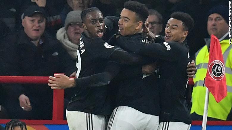 Marcus Rashford, who is hidden, celebrates with teammates after scoring Manchester United&#39;s third goal.