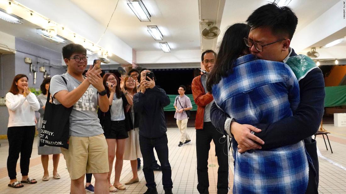 Pro-democracy candidate James Yu hugs his girlfriend after winning his seat in district council elections, early November 25.