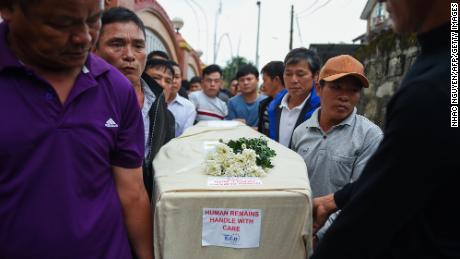 Relatives carry the casket bearing the body of migrant Nguyen Van Hung on arrival in Hanoi on November 27, 2019.