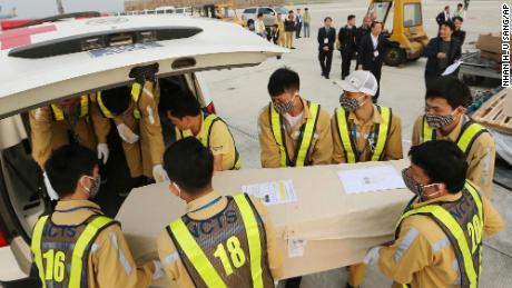 Airport personnel load a coffin into an ambulance in Hanoi on November 27, 2019.