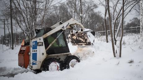 A man plows snow Wednesday after a blizzard struck Minneapolis.