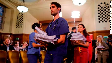 NHS workers hand out documents on the Conservative government&#39;s UK-US trade talks during a a press conference by the opposition Labour party leader Jeremy Corbyn.