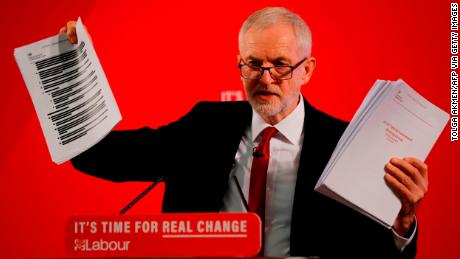 Opposition Labour party leader Jeremy Corbyn holds up redacted documents from the government&#39;s UK-US trade talks during a press conference in London.