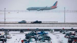 DENVER, CO - NOVEMBER 26: A jet passes snow-covered cars parked at Denver International Airport on November 26, 2019 in Denver, Colorado. Flights were delayed and rescheduled due to a winter storm that dropped nearly a foot of snow in the city. (Photo by Joe Mahoney/Getty Images)