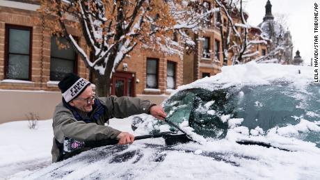 Patrick Costanzo brushes snow off a friend&#39;s car in St. Paul, Minnesota.