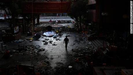 A man walks past debris littering the entrance at the Hong Kong Polytechnic University campus in the Hung Hom district of Hong Kong on November 27, 2019, over a week after police surrounded the building while protesters were still barricaded inside. - Teams at one of Hong Kong&#39;s top universities picked through the chaotic aftermath of a violent occupation by protesters for a second day on November 27 as the school searches for elusive holdouts -- and a way forward for a devastated institution. (Photo by Anthony WALLACE / AFP) (Photo by ANTHONY WALLACE/AFP via Getty Images)