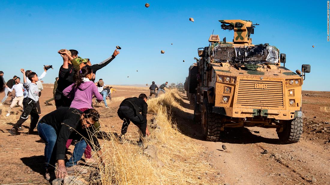 Kurdish demonstrators hurl rocks at a Turkish military vehicle on Friday, November 8, during a joint Turkish-Russian patrol near the town of Al-Muabbadah in the northeastern part of Hassakah on the Syrian border with Turkey. 