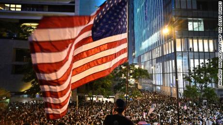 A man waves a US flag as protesters attend a rally in Hong Kong on October 14, 2019, calling on US politicians to pass a bill that could alter Washington&#39;s relationship with the trading hub.