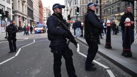 Armed policman stand guard at Cannon Street station in central London, on Friday.