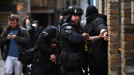 Police apprehend a man in a street on the south side of London Bridge on Friday.