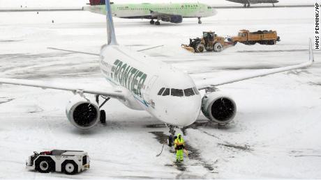 Crews remove snow as flights resume Monday at Albany International Airport in New York.