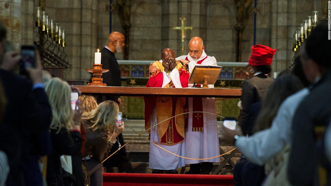 Tutu is comforted by Dean Michael Weeder as he cries during a Mass to mark his 85th birthday in 2016.