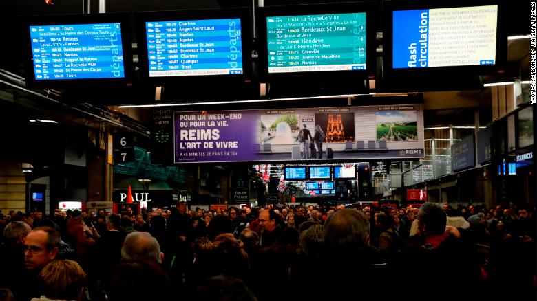 Commuters walk inside Montparnasse train station in Paris on December 4, 2019, on the eve of a national strike over pension reforms.