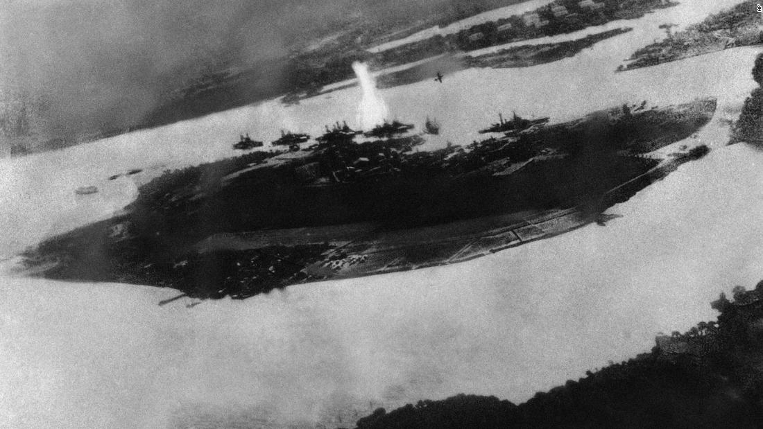 This is believed to be an image of the first bomb on Pearl Harbor; it shows a Japanese plane pulling out of a dive near the explosion.