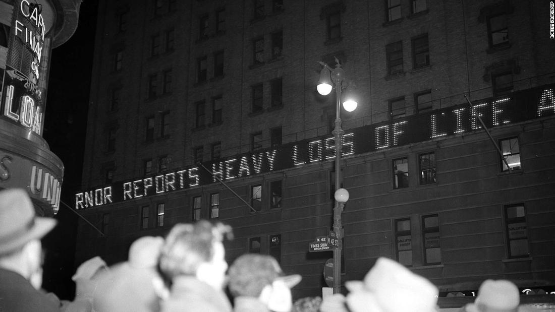 Crowds gather in New York&#39;s Times Square as news bulletins about the attack flash across the New York Times building.