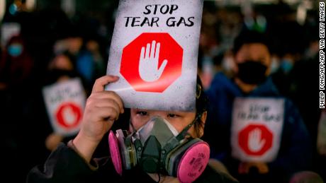 A participant wearing a protective mask holds a placard during a &quot;Say no to tear gas&quot; rally at Edinburgh place in Hong Kong on December 6, 2019. (Photo by Philip FONG / AFP) (Photo by PHILIP FONG/AFP via Getty Images)
