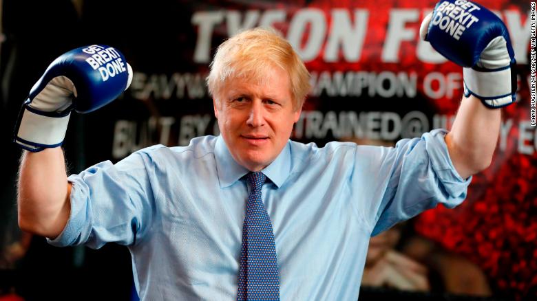 Britain&#39;s Prime Minister and leader of the Conservative Party, Boris Johnson wears boxing gloves emblazoned with &quot;Get Brexit Done&quot; as he poses for a photograph at Jimmy Egan&#39;s Boxing Academy in Manchester north-west England on November 19, 2019, during a general election campaign trip.