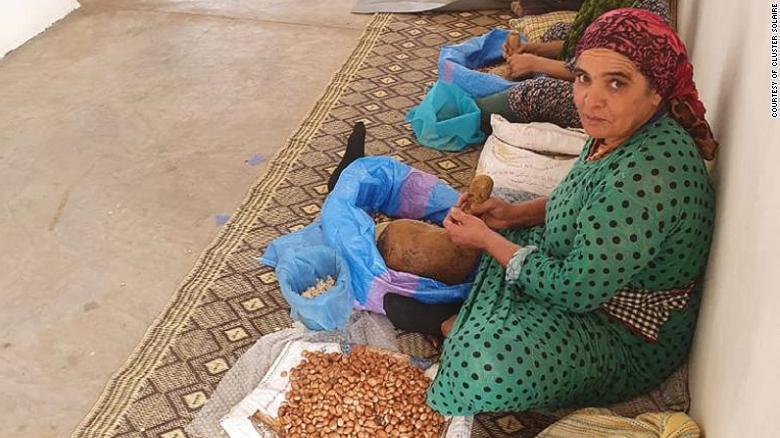 A woman crushing argan oil from the argan tree kernel using traditional methods at the  workshop.