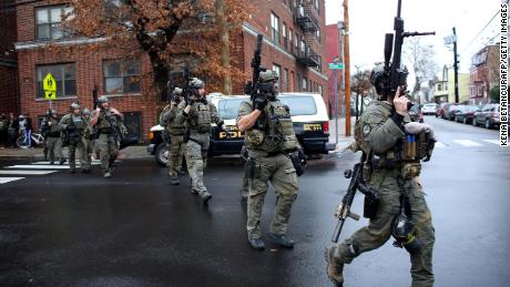 Police officers arrive to the scene where an active shooting was taking place in Jersey City, New Jersey.