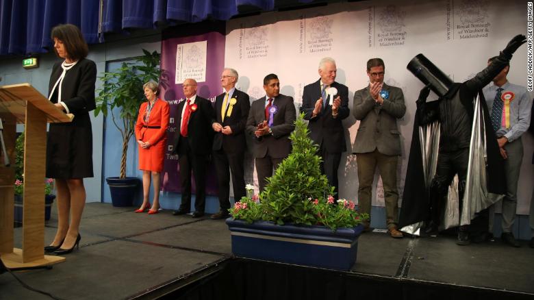 Theresa May (left) and Lord Buckethead (second from right, with the bucket on his head) hear the results in their constituency in 2017.