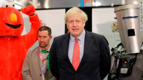 Bobby Smith, a political and fathers&#39; rights activist and founder and leader of the &#39;Give Me Back Elmo&#39; party, left, and Independent candidate Count Binface stand either side of Britain&#39;s Prime Minister and Conservative Party leader Boris Johnson wait for the Uxbridge and South Ruislip constituency count declaration at Brunel University in Uxbridge, London, Friday, Dec. 13, 2019. (AP Photo/Kirsty Wigglesworth)
