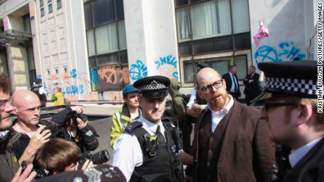 Police arresting Simon Bramwell for super gluing himself to the Shell Centre in London in April.