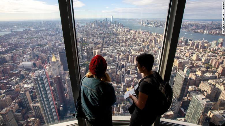 Visitors look toward Lower Manhattan from the 102nd floor observatory of the Empire State Building  