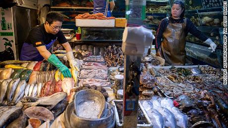 Workers prepare a stall filled with seafood at a market in Beijing on July 10, 2019. - Factory prices in China were unchanged in June from a year ago, data showed on July 10, reviving the prospect of deflation as the US trade war hits the crucial manufacturing sector. At the same time consumer prices managed to meet expectations but the main support came from a surge in food prices owing to the impact of African swine fever on pork supplies and severe weather hitting fresh fruits. (Photo by Nicolas ASFOURI / AFP)        (Photo credit should read NICOLAS ASFOURI/AFP via Getty Images)