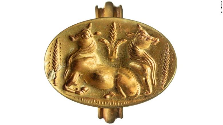 Un anello d'oro raffigura due tori affiancati da covoni di grano.