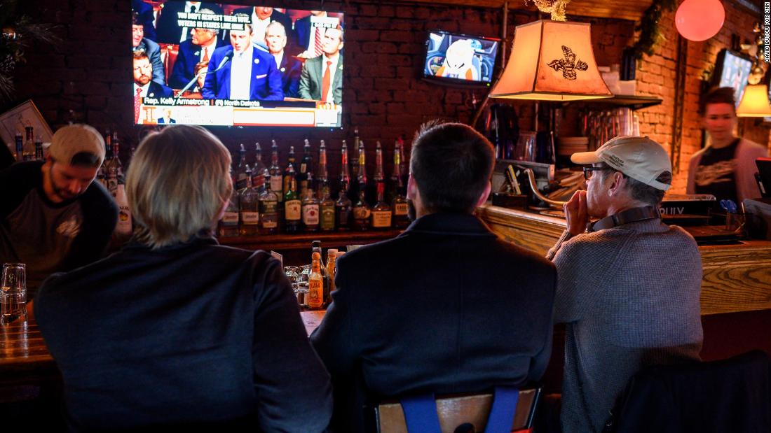 Patrons at the Capitol Lounge, close to the US Capitol, watch television coverage as the House prepares to vote on impeachment.