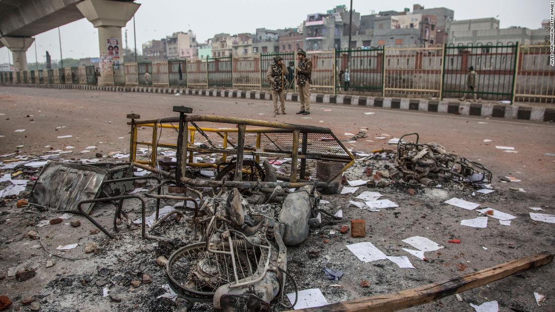 Policemen stand near the wreckage of motorcycles which were set on fire during protests in New Delhi, December 17.