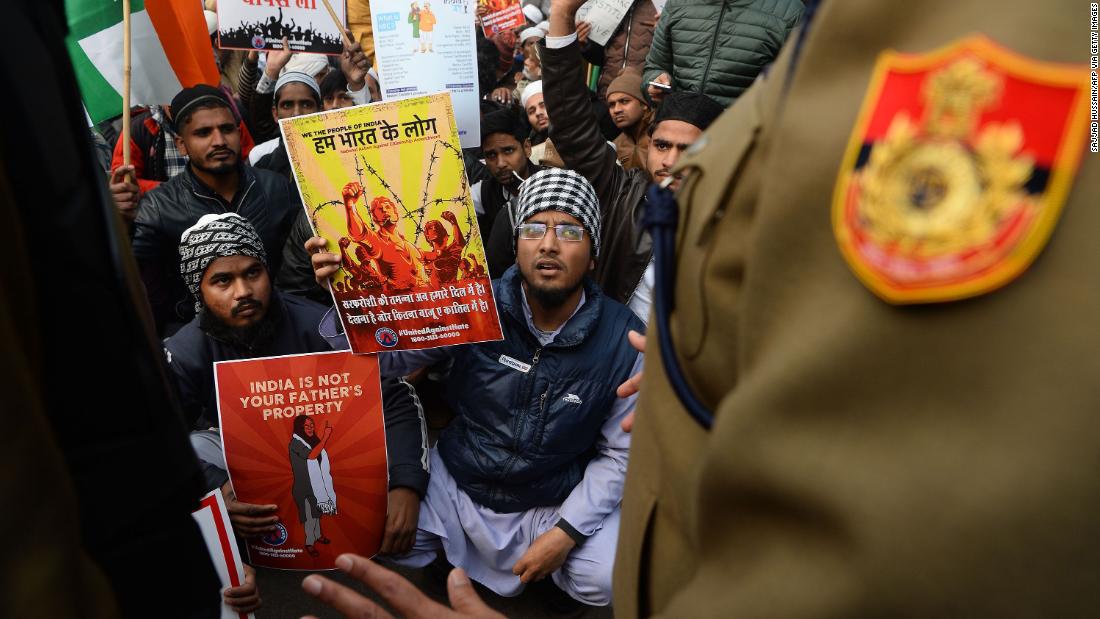 A policeman confronts protesters gathered for a demonstration in New Delhi on December 19.