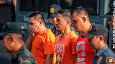Suspects in the Maguindanao Massacre are escorted by policemen as they arrive at Camp Bagong Diwa, where a court will issue a verdict on the crime, on December 19, 2019 in Manila, Philippines.