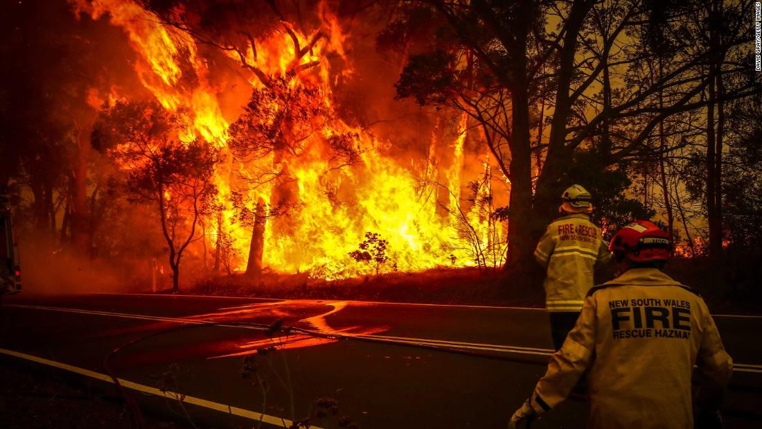 Fire and rescue personnel monitor a bushfire as it burns near homes on the outskirts of Bilpin on Thursday, December 19.