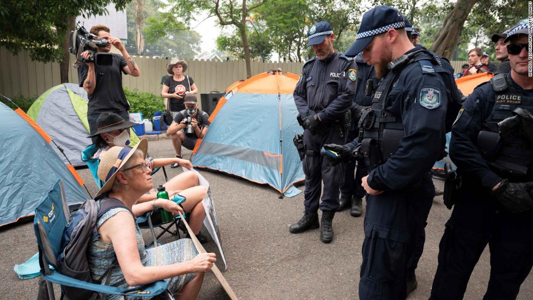 Police disperse demonstrators during a climate protest near Australian Prime Minister Scott Morrison&#39;s official residence in Sydney, on December 19, during his absence on an overseas holiday, as bushfires burned across the region.