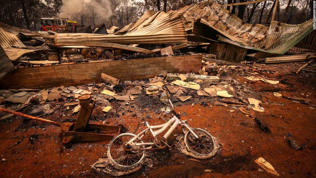 A charred bicycle lies on the ground in front of a house destroyed by bushfires on the outskirts of Bargo on December 21.