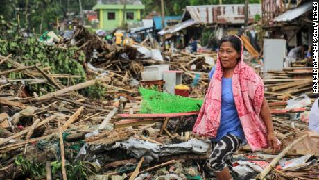 A resident walks past debris from her destroyed houses after Typhoon Kammuri hit the city of Sorsogon, south of of Manila.