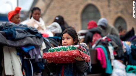 Briella Jones 5, who lived in the Francis Drake Hotel apartments with her family, holds donated Christmas presents.