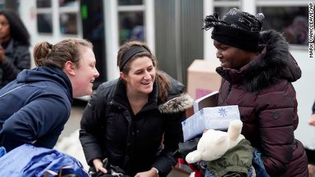 Nicole Williamson, right, a resident of the Francis Drake Hotel apartment building, receives a donated gift box containing skin care and other personal items after the building caught a fire Wednesday.