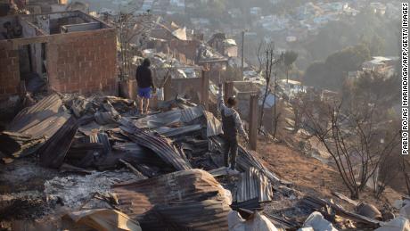 Residents look at the destruction caused by the fires in Valparaiso.