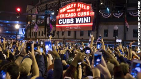 Chicago fans celebrate the Chicago Cubs&#39; 8-7 victory over the Cleveland Indians outside Wrigley Field.