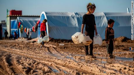 Children carry jugs to fill with water in the Washukanni camp for internally displaced people in northeastern Syria.