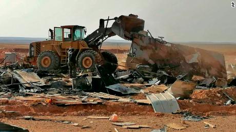 Fighters with the Kataib Hezbollah militia search for bodies in the aftermath of a US airstrike.