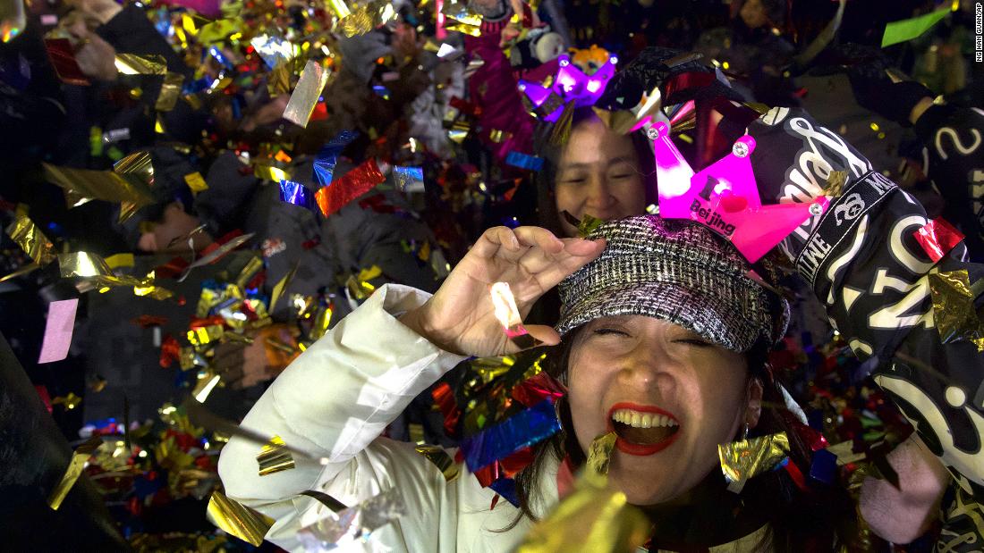 People celebrate the new year near the 2022 Beijing Winter Olympic headquarters.